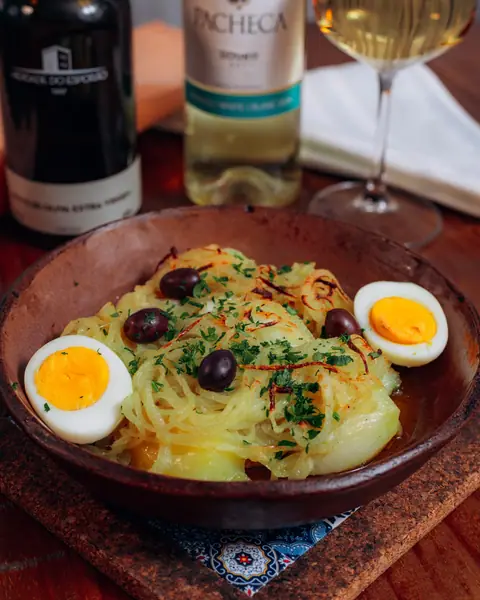 Lascas de bacalhau com ovos e azeitonas, com vinho branco